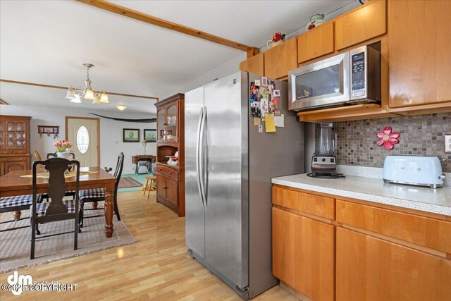 3669 Pullen Cir, Eagle River, AK 99577 - kitchen with appliances with stainless steel finishes, tasteful backsplash, light countertops, light wood-style flooring, and a chandelier