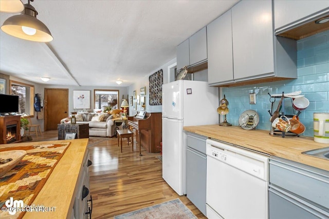 3669 Pullen Cir, Eagle River, AK 99577 - kitchen with white appliances, wood counters, open floor plan, light wood finished floors, and tasteful backsplash