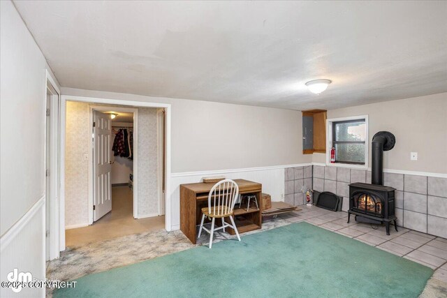 3669 Pullen Cir, Eagle River, AK 99577 - sitting room with a wood stove, a wainscoted wall, electric panel, and tile patterned flooring