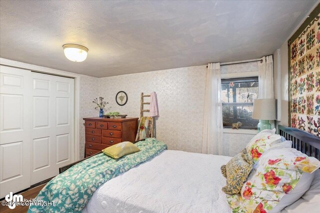 3669 Pullen Cir, Eagle River, AK 99577 - bedroom with wallpapered walls, a closet, and wood finished floors