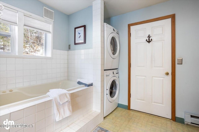 3669 Pullen Cir, Eagle River, AK 99577 - laundry room with stacked washing machine and dryer, a baseboard heating unit, and light floors