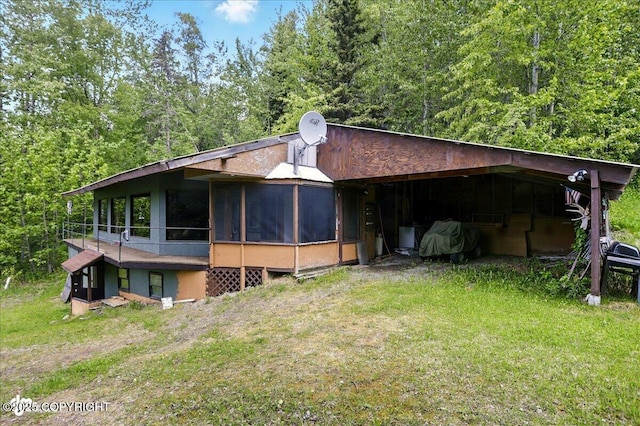 3669 Pullen Cir, Eagle River, AK 99577 - view of property exterior featuring a sunroom, a carport, and a view of trees