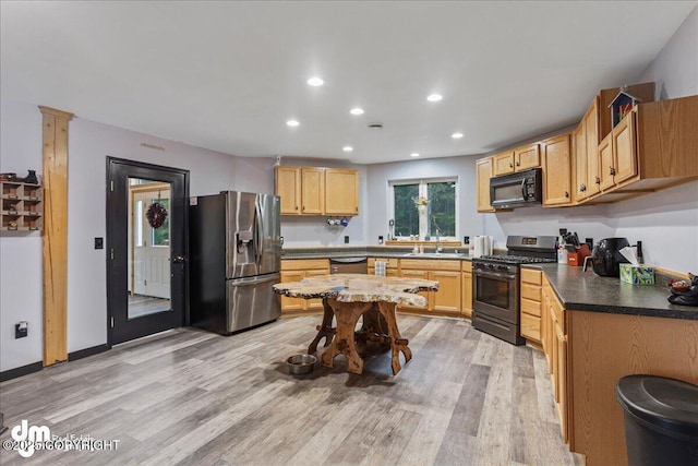 10912 Wolf Trail Cir, Seward, AK 99664 - kitchen with stainless steel appliances, recessed lighting, light wood-style flooring, dark countertops, and light brown cabinetry