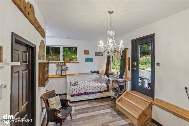 10912 Wolf Trail Cir, Seward, AK 99664 - bedroom featuring wood finished floors, a chandelier, and access to exterior