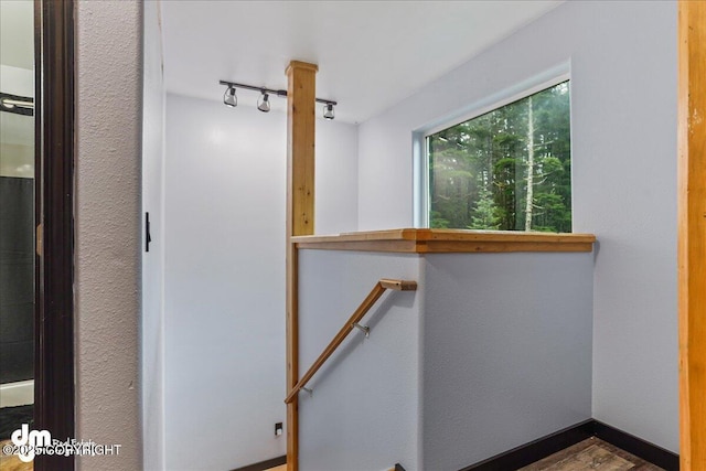 10912 Wolf Trail Cir, Seward, AK 99664 - hall featuring an upstairs landing, track lighting, and wood finished floors