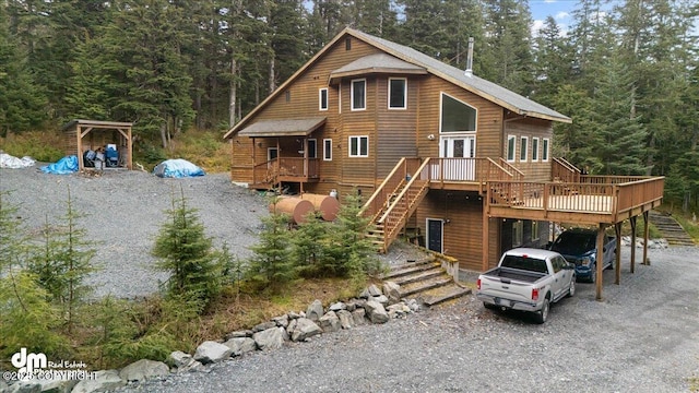 10912 Wolf Trail Cir, Seward, AK 99664 - rustic home featuring stairs, gravel driveway, a deck, and a view of trees