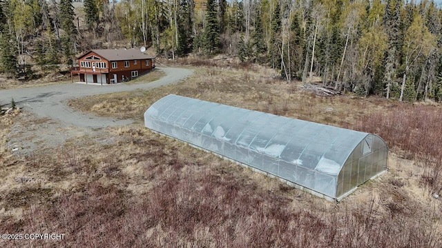 575 Pace St, Soldotna, AK 99669 - view of property's community with a greenhouse, an outbuilding, a wooden deck, and a view of trees