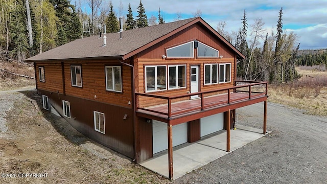 575 Pace St, Soldotna, AK 99669 - rear view of property with a wooden deck, an attached garage, roof with shingles, and driveway