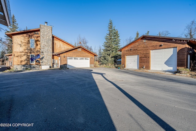 view of side of property featuring a chimney and a garage