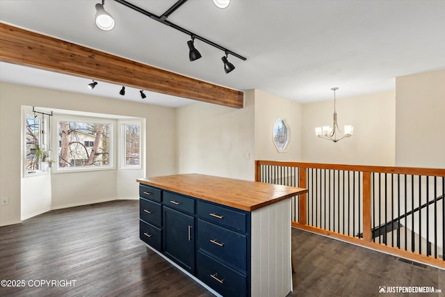 3810 Midvale Cir, Anchorage, AK 99507 - kitchen with butcher block counters, an inviting chandelier, rail lighting, blue cabinetry, and dark wood-style floors