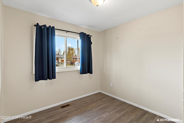 3810 Midvale Cir, Anchorage, AK 99507 - unfurnished room featuring baseboards, visible vents, a textured ceiling, and wood finished floors