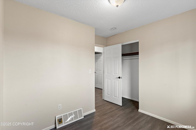 3810 Midvale Cir, Anchorage, AK 99507 - unfurnished bedroom featuring a closet, a textured ceiling, baseboards, dark wood finished floors, and visible vents