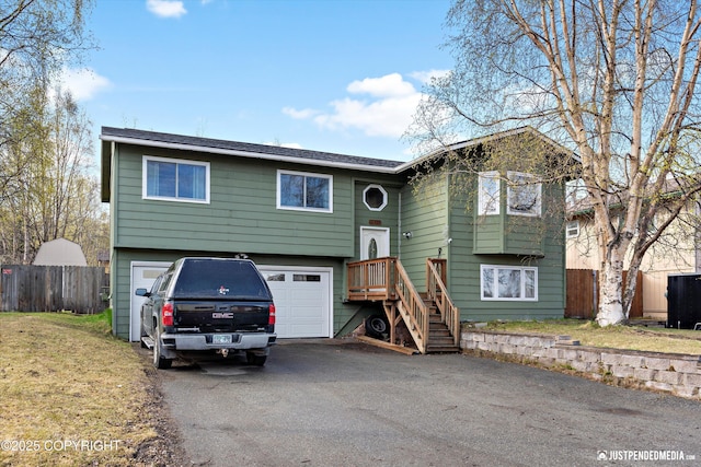 3810 Midvale Cir, Anchorage, AK 99507 - bi-level home featuring cooling unit, aphalt driveway, an attached garage, and fence