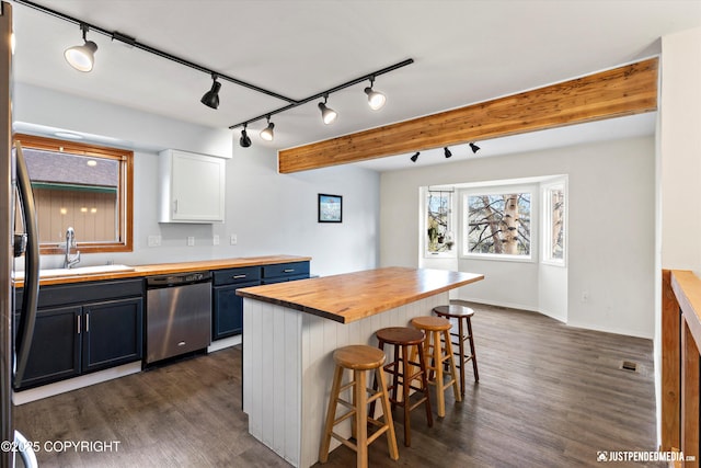 3810 Midvale Cir, Anchorage, AK 99507 - kitchen with a kitchen bar, a sink, track lighting, stainless steel dishwasher, and butcher block counters