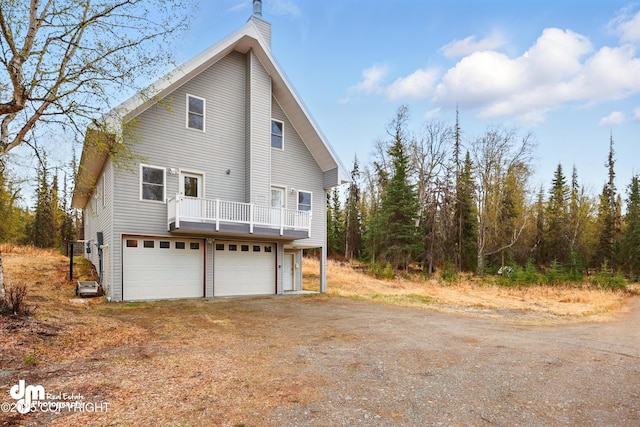 29425 Fools Gold St, Soldotna, AK 99669 - view of side of home featuring a chimney, an attached garage, and driveway
