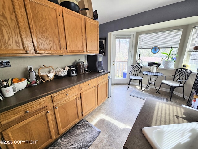1902 Swetmann Ave, Seward, AK 99664 - kitchen featuring dark countertops, brown cabinetry, and a wealth of natural light