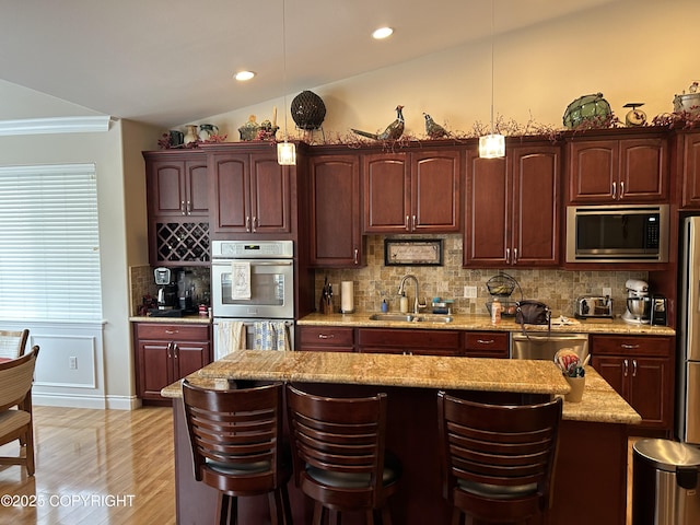 5789 S Hanson Loop, Wasilla, AK 99654 - kitchen featuring a sink, stainless steel appliances, a kitchen breakfast bar, tasteful backsplash, and pendant lighting