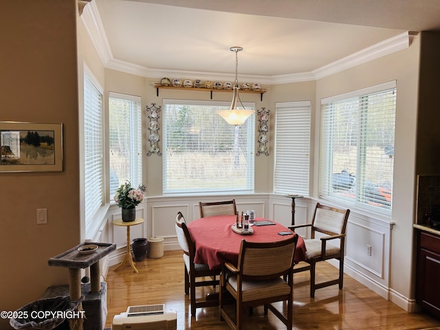5789 S Hanson Loop, Wasilla, AK 99654 - dining area featuring ornamental molding, light wood-type flooring, plenty of natural light, and a wainscoted wall