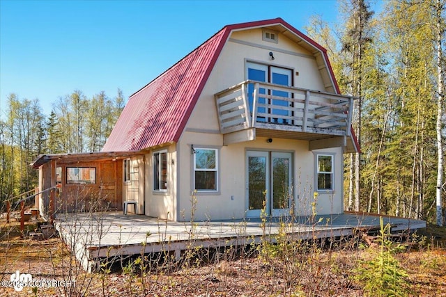 8266 S Big Lake Rd, Big Lake, AK 99652 - back of property featuring a balcony, a gambrel roof, metal roof, and a deck