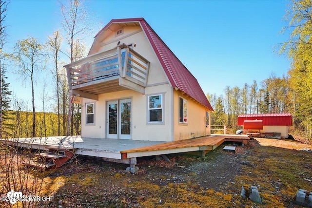 8266 S Big Lake Rd, Big Lake, AK 99652 - back of property featuring a balcony, a wooden deck, metal roof, and a gambrel roof