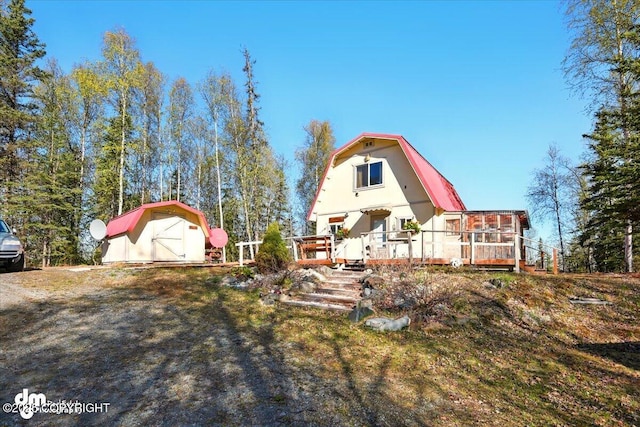 8266 S Big Lake Rd, Big Lake, AK 99652 - back of house featuring a gambrel roof, a shed, an outbuilding, and a deck