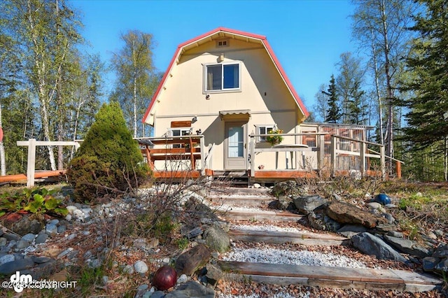 8266 S Big Lake Rd, Big Lake, AK 99652 - view of front facade featuring a wooden deck and a gambrel roof
