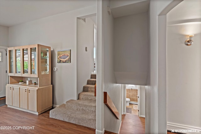 6700 Omalley Rd, Anchorage, AK 99507 - stairway with baseboard heating and wood finished floors