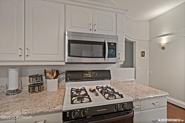 6700 Omalley Rd, Anchorage, AK 99507 - kitchen featuring stainless steel microwave, gas stove, white cabinets, and wood finished floors
