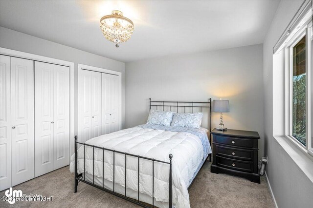 3412 Red Rock Ct, Anchorage, AK 99502 - carpeted bedroom with an inviting chandelier and multiple closets