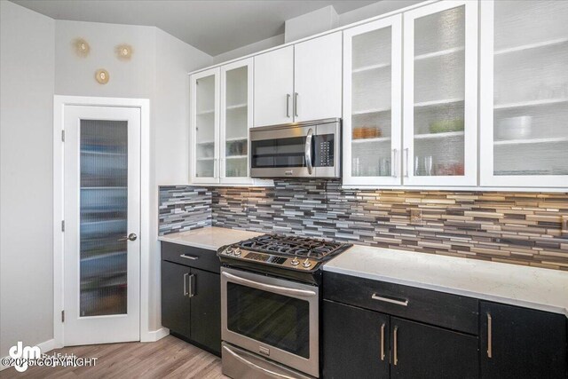 3412 Red Rock Ct, Anchorage, AK 99502 - kitchen featuring white cabinets, dark cabinets, appliances with stainless steel finishes, and light wood-type flooring