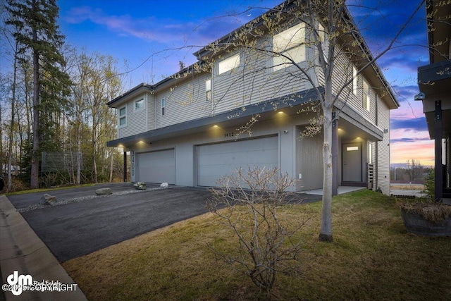 3412 Red Rock Ct, Anchorage, AK 99502 - property exterior at dusk featuring a lawn, driveway, and a garage