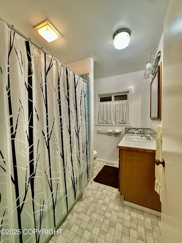 33434 Nash Rd, Seward, AK 99664 - bathroom featuring vanity, baseboards, toilet, and curtained shower