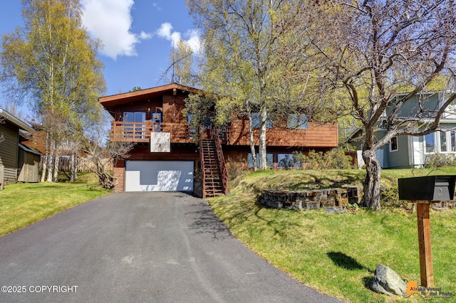 view of front of property featuring a garage, stairway, driveway, and a front lawn