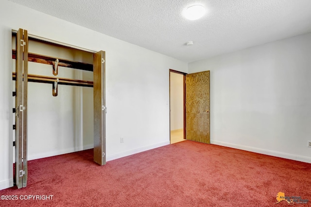 unfurnished bedroom featuring carpet floors, a textured ceiling, a closet, and baseboards