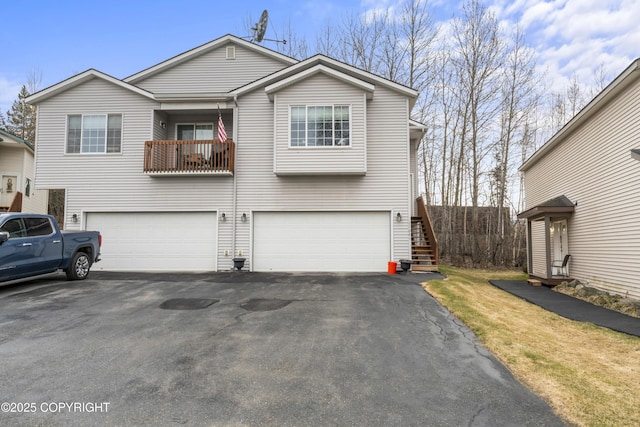 view of front of property with stairway, an attached garage, and driveway