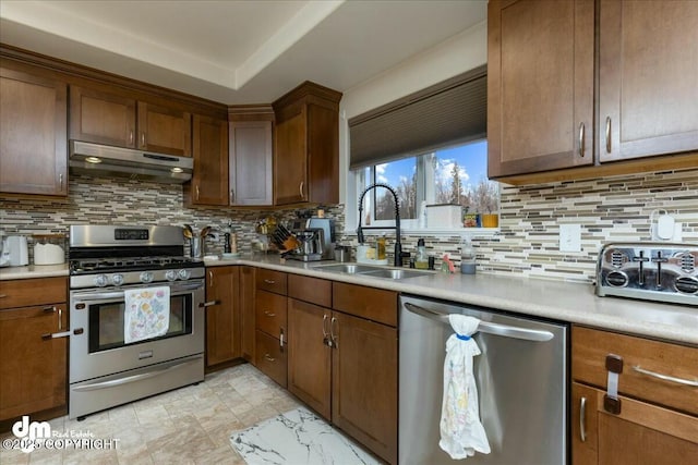 8000 Cox Dr, Anchorage, AK 99516 - kitchen with a sink, decorative backsplash, stainless steel appliances, under cabinet range hood, and light countertops