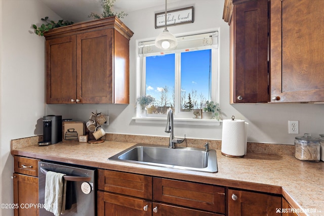 kitchen with a sink, light countertops, decorative light fixtures, and dishwasher