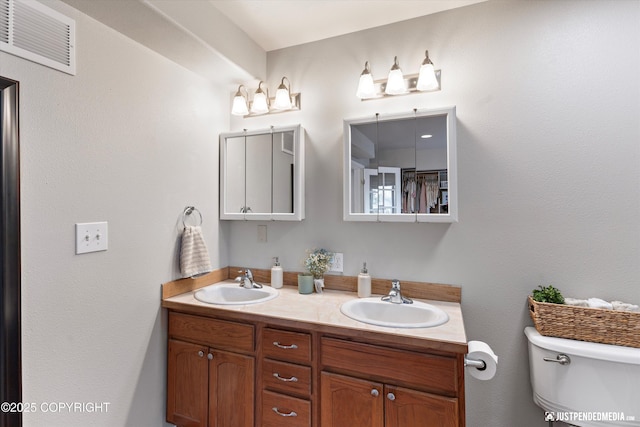 bathroom featuring a sink, toilet, double vanity, and visible vents