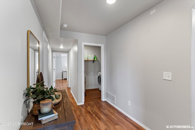 corridor with visible vents, washer / dryer, wood finished floors, baseboards, and recessed lighting