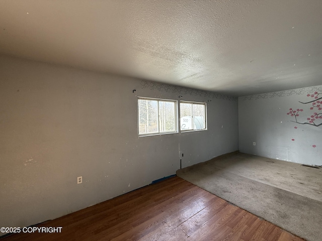 spare room with a textured ceiling and wood finished floors