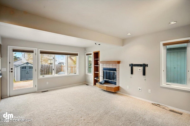 12100 Woodway Cir, Anchorage, AK 99516 - unfurnished living room with carpet flooring, a tiled fireplace, baseboards, and recessed lighting