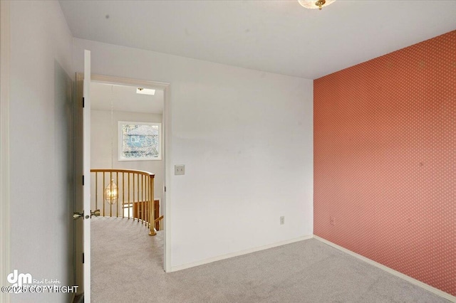 12100 Woodway Cir, Anchorage, AK 99516 - empty room featuring carpet flooring, wallpapered walls, an accent wall, and baseboards