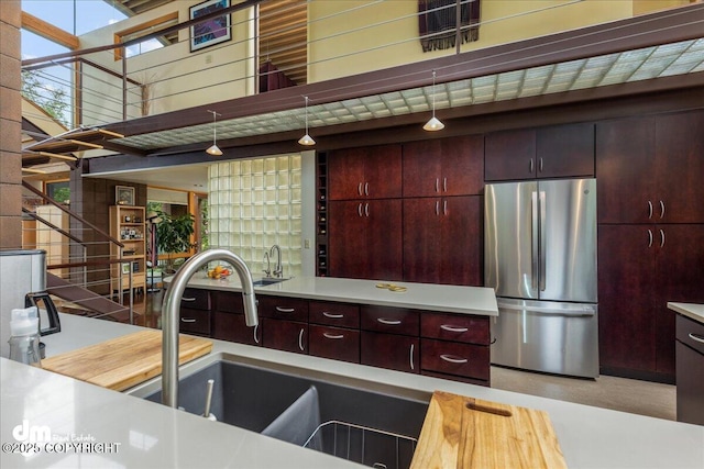kitchen featuring freestanding refrigerator, a sink, and light countertops