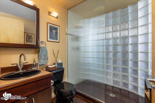 bathroom featuring vanity, toilet, and tiled shower
