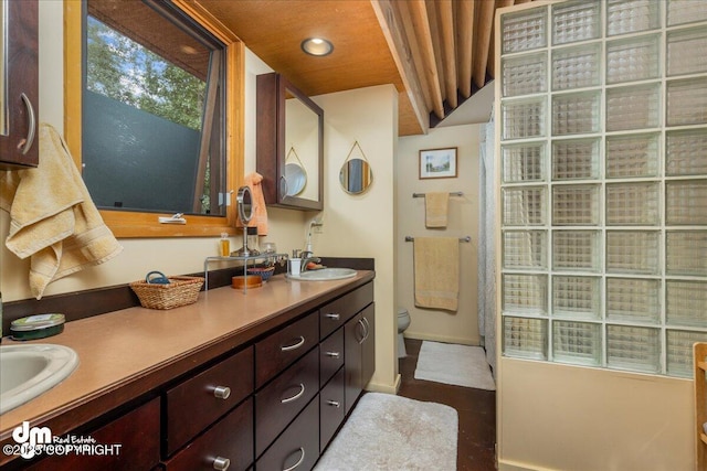 full bathroom with double vanity, toilet, recessed lighting, and a sink