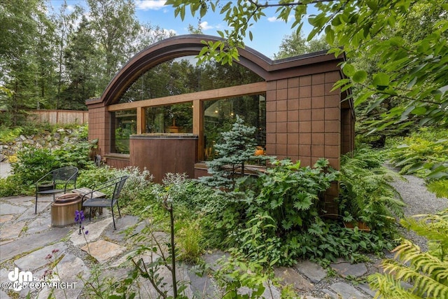 exterior space featuring an outdoor fire pit and fence