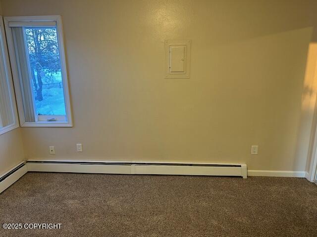 carpeted empty room featuring a baseboard radiator and baseboards