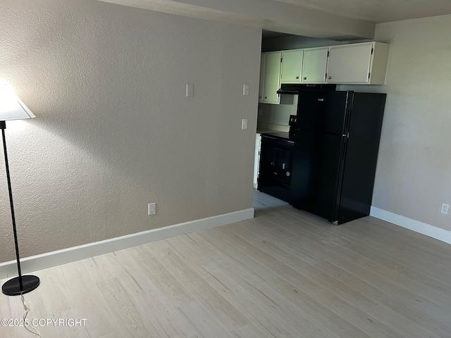 kitchen featuring black appliances, light wood-style flooring, baseboards, and white cabinets