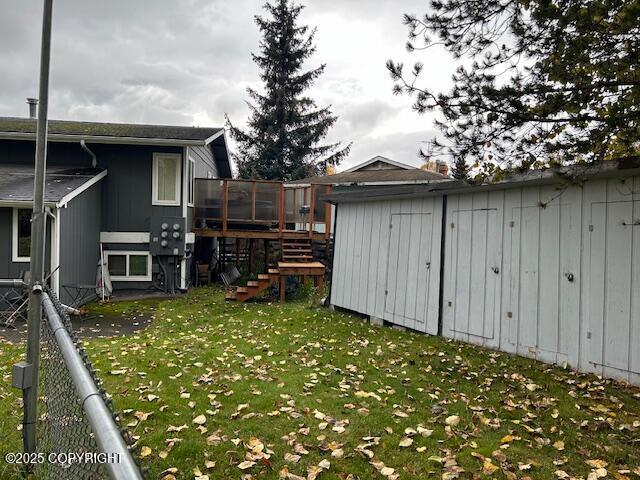 view of yard with stairs, a shed, an outbuilding, and a wooden deck