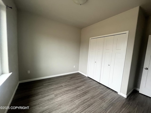 49045 Gemini Ct, Soldotna, AK 99669 - unfurnished bedroom featuring baseboards, a closet, and dark wood-style floors